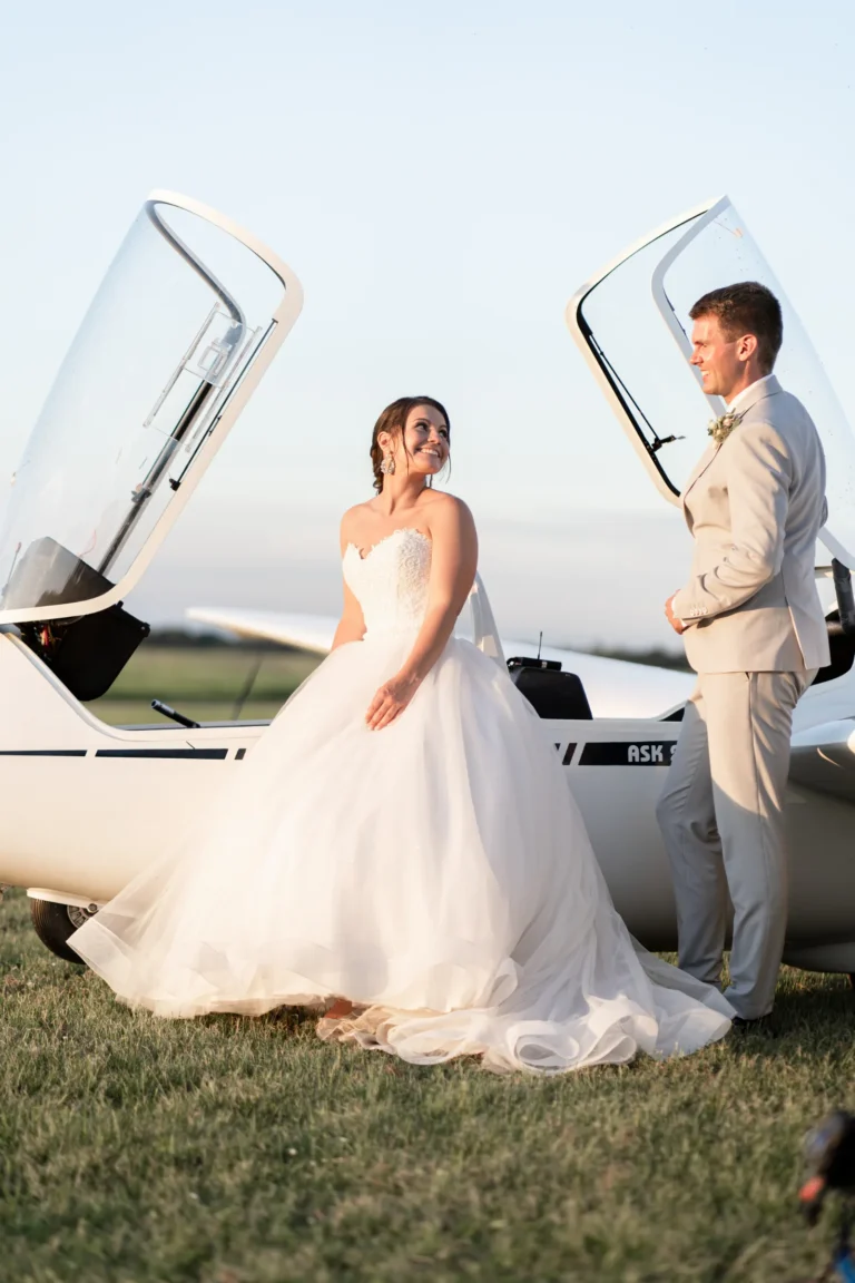 Nahaufnahme von Brautpaar am Flugzeug, aufgenommen von Hochzeitsfotograf Tom Hartmann aus Bochum von weddingpicture aus Bochum, mit besonderem Fokus auf die Intimität und den einzigartigen Moment vor einer eindrucksvollen Kulisse.